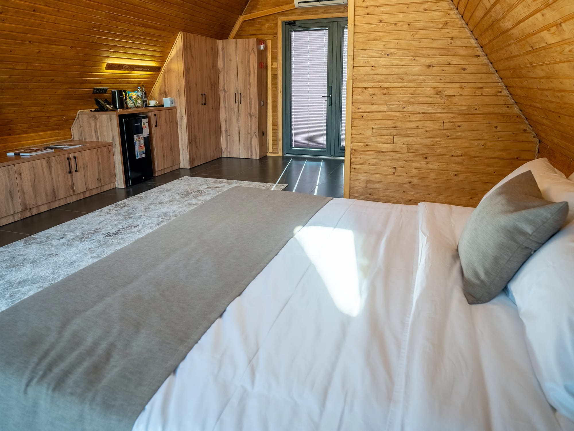 A-frame yog'och gumbazi ostidagi ikki kishilik karavot